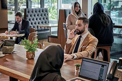 Professionals work and communicate efficiently in a sophisticated Servcorp coworking space in Saudi Arabia, designed for productivity and comfort.