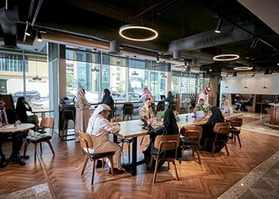 Professionals collaborate in a vibrant Servcorp coworking space in Saudi Arabia, blending modern design with a dynamic business atmosphere.