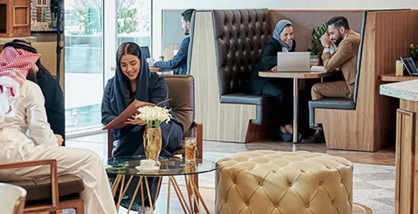Professionals connect and collaborate in a stylish Servcorp coworking lounge in Saudi Arabia.